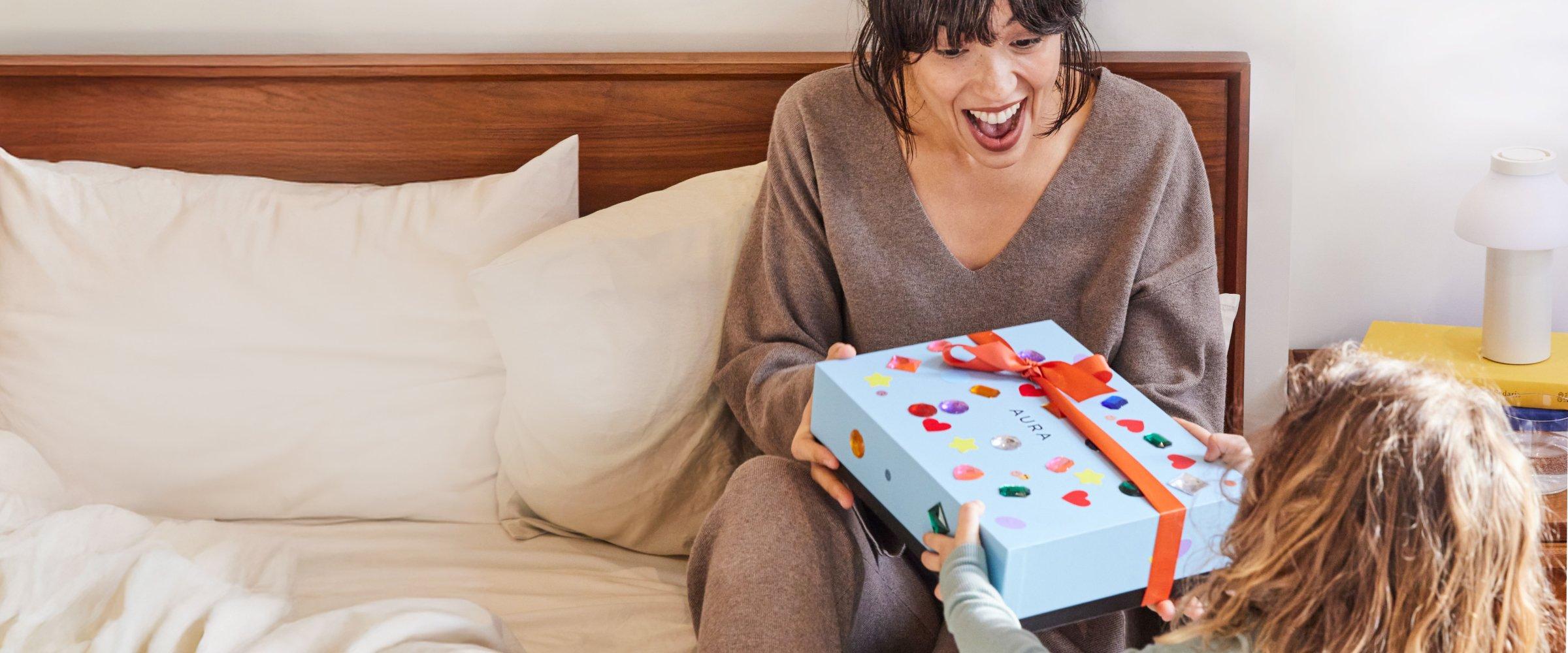 An excited mom recieving an Aura frame as a gift.