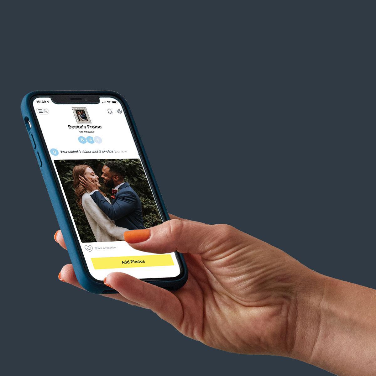 A hand holding a cell phone open to the Aura app