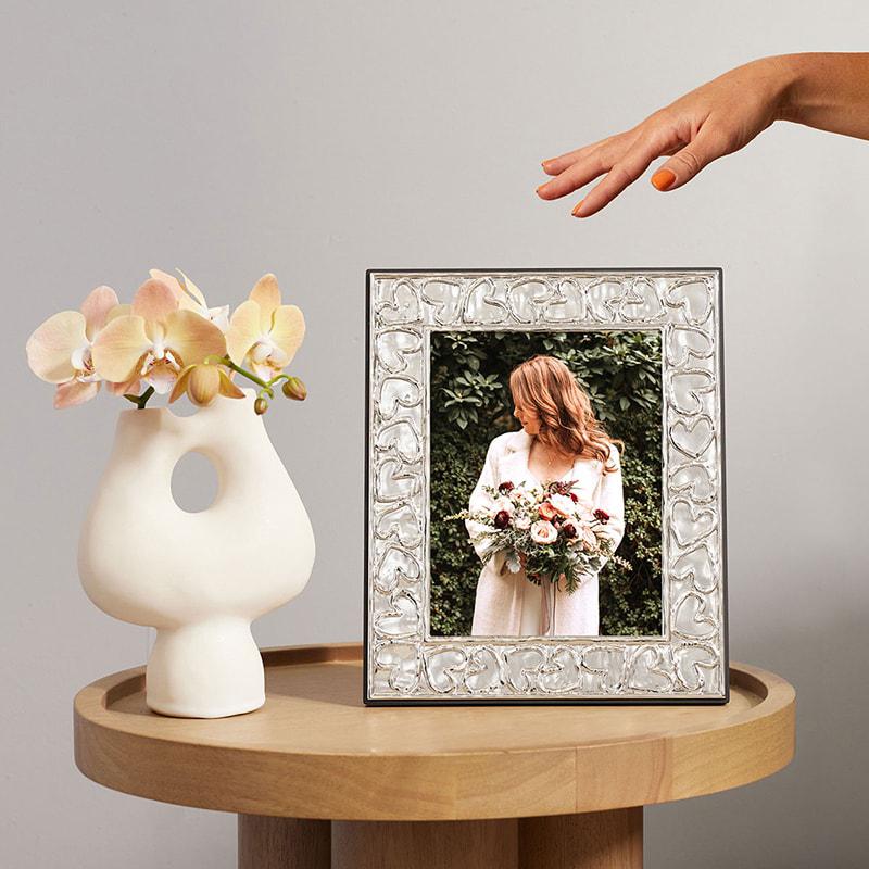 Aram picture frame on a side table with a wedding photo