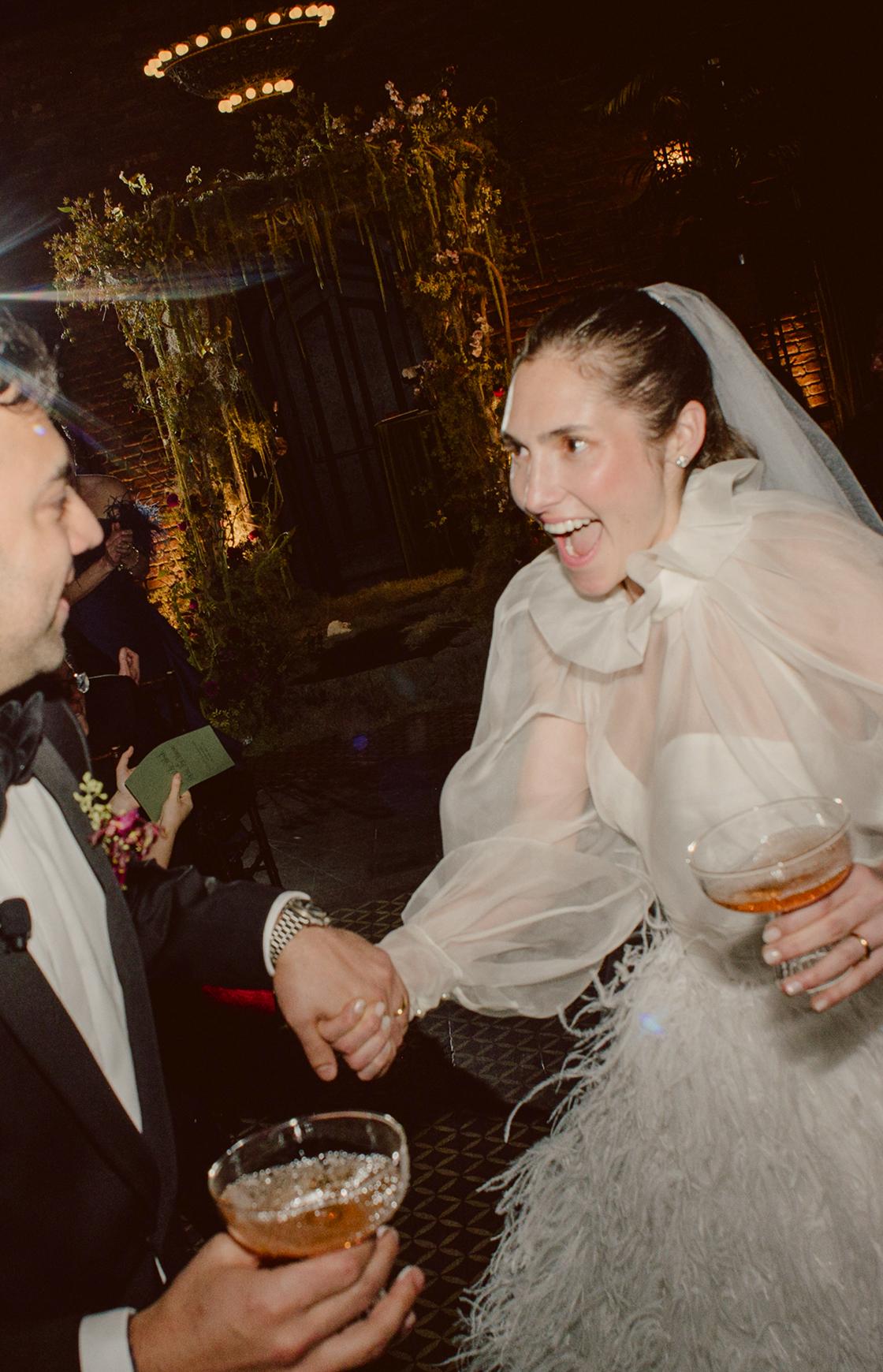 A photo of a bride and groom sitting on a wooden bench
