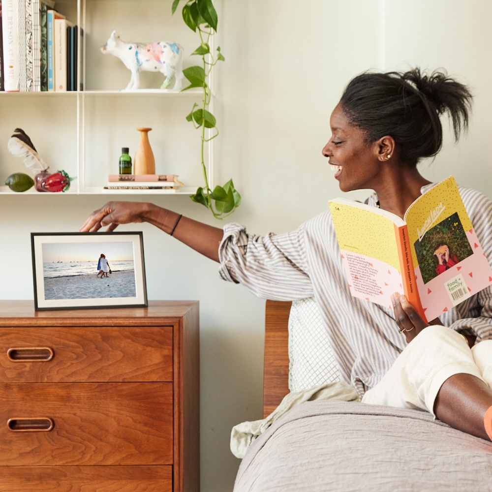 Gifting Step 4: Woman looking at new photos on frame