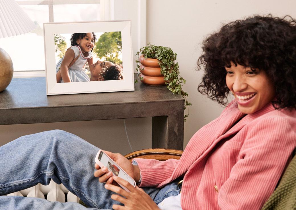 A woman looking at her smartphone and the Carver Mat frame