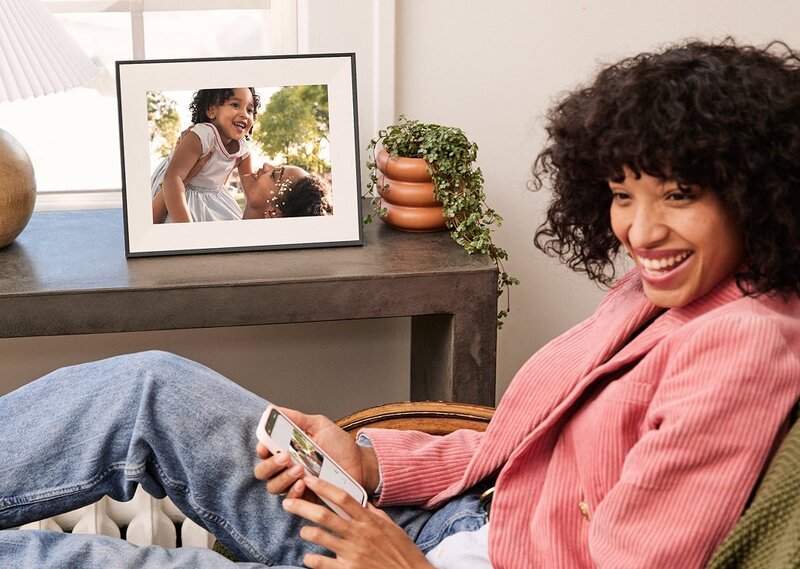 A woman looking at her smartphone and the Carver Mat frame
