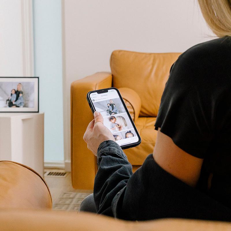 A woman looking at her smartphone and the Carver Mat frame