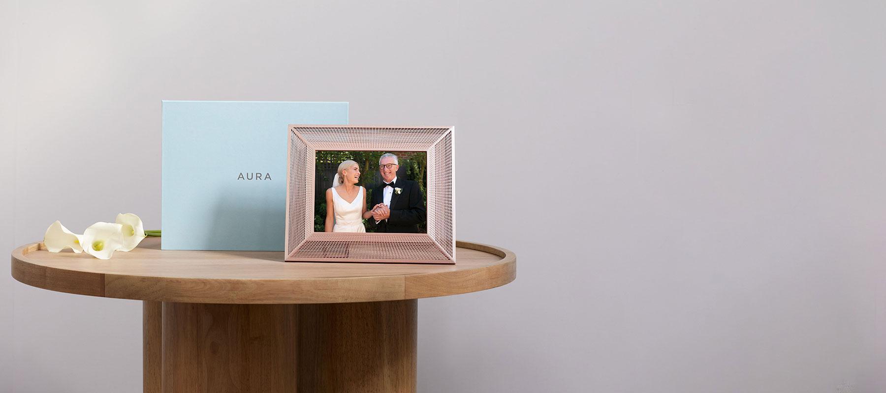 Aura Arama frame sitting on a side table showing a wedding couple